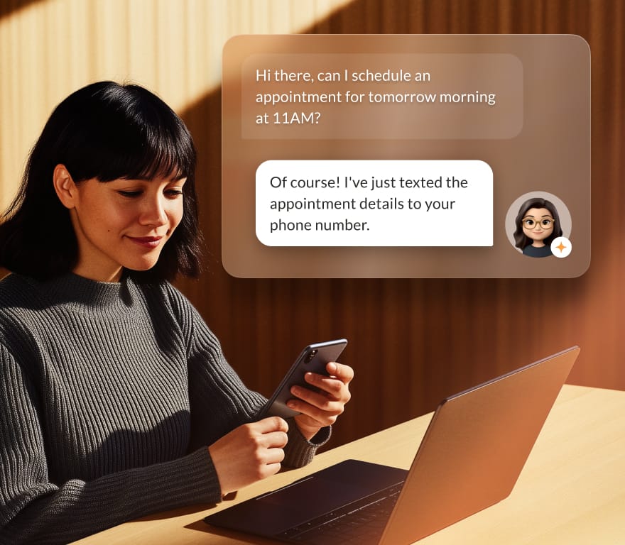 A woman holding her phone in front of her laptop, using RingCentral's AI Receptionist to book an appointment.